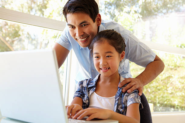 Father and daughter using laptop Father and daughter using laptop together philippine girl stock pictures, royalty-free photos & images