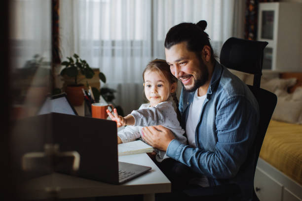 Father and daughter working together at home stock photo