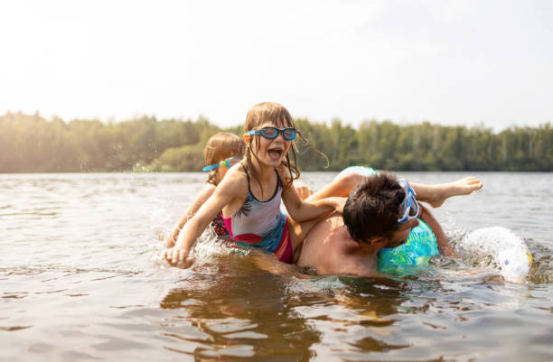vader en kinderen die pret in het meer hebben - nederland strand stockfoto's en -beelden