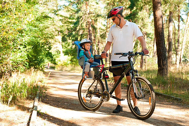 Father and little son on bike with child seat stock photo