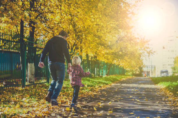 Father and Little Son Walking Outdoors in Autumn stock photo