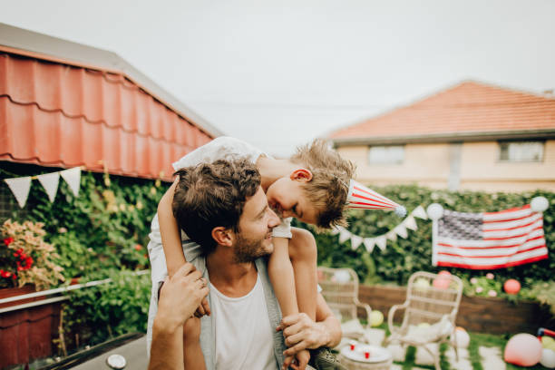 vader en zoon vieren vierde van juli - family garden,party stockfoto's en -beelden