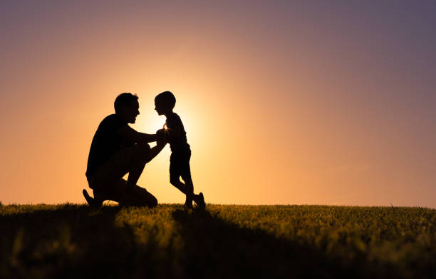 Father and son enjoying beautiful sunset in the park. stock photo