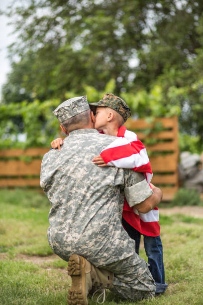 Father and son Happy family reunited father soldier and his son holding american flag outdoors tender scene soldiers returning home stock pictures, royalty-free photos & images