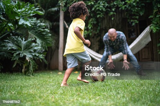 143072114istockphoto Father And Son Playing With Soccer Ball