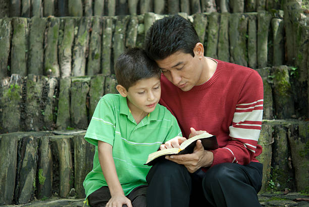 father and son reading stock photo