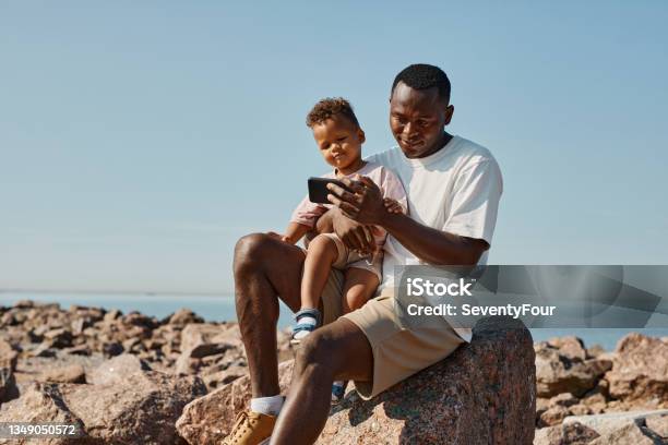 Father and Son Taking Photo at Beach