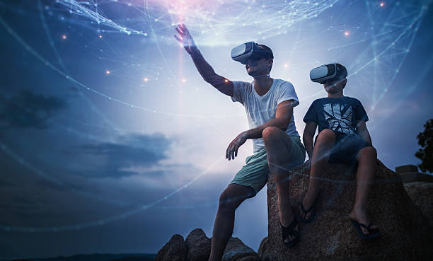 father and son using virtual reality glasses sitting outside - future kids stockfoto's en -beelden