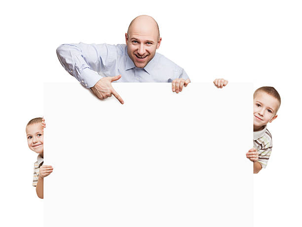 Father and sons holding blank sign or placard stock photo