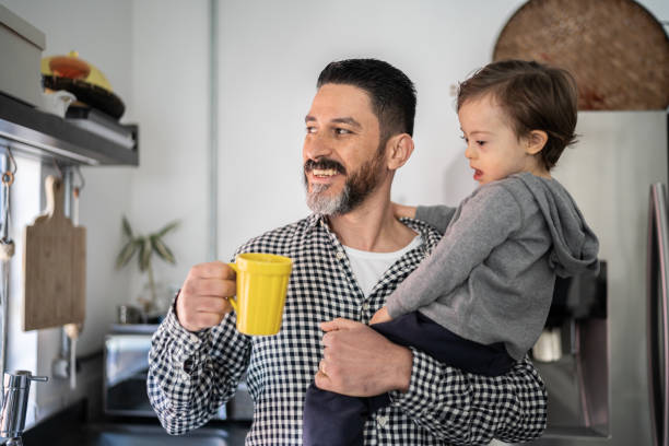 Father carrying son and having a coffee at home Father carrying son and having a coffee at home fathers day stock pictures, royalty-free photos & images