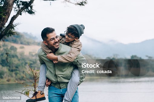 istock Father carrying son on his back 1340101908