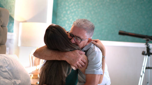 Father embracing daughter at home Father embracing daughter at home fathers day stock pictures, royalty-free photos & images