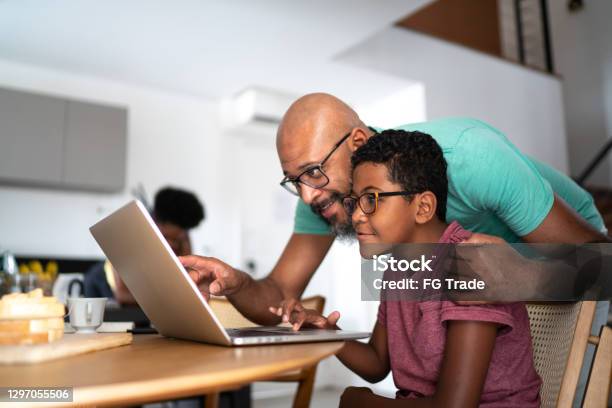 Father encouraging son on homeschooling or doing a video call/watching a movie