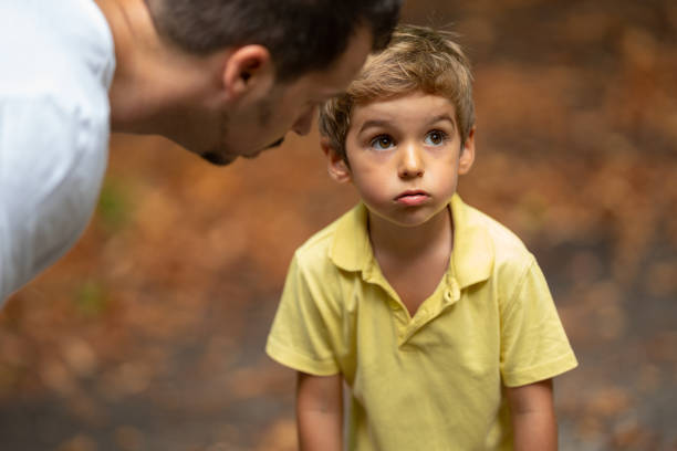 father explaining little boy son how to behave stock photo