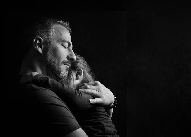Father Hugging Daughter Tenderly stock photo