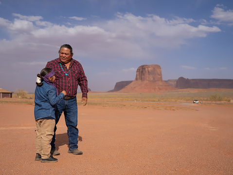 Indigenous navajo Father talking to his boy in Monument Valley