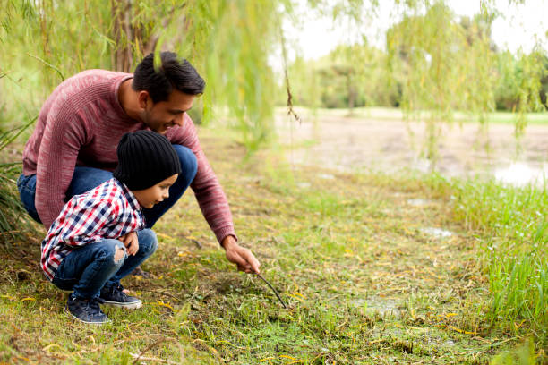padre enseña a su hijo sobre la naturaleza - latin family fotografías e imágenes de stock