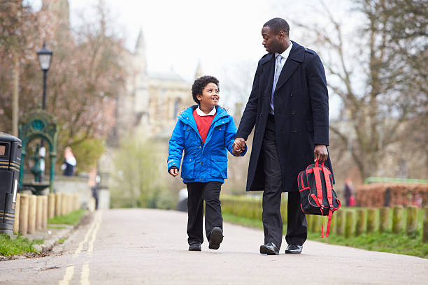 Father Walking Son To School Along Path stock photo