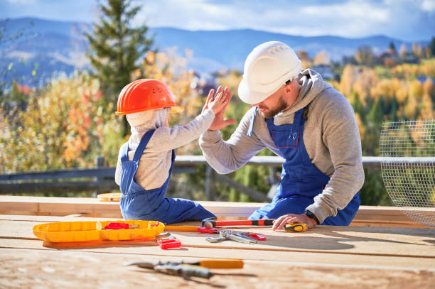 Father with toddler son building wooden frame house. stock photo