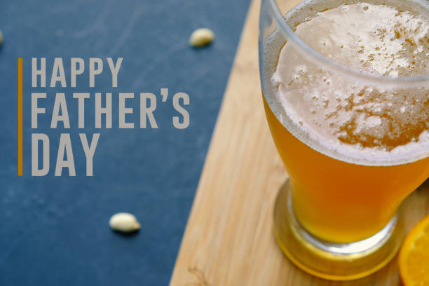 Father's Day graphic with beer and text. Happy father's day graphic with pint of beer and snacking peanuts in background.  Text for holiday card or banner on black background. fathers day stock pictures, royalty-free photos & images