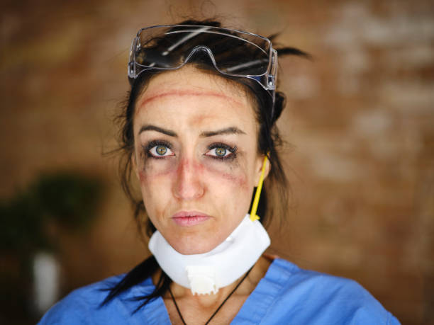 Fatigued Healthcare Worker A healthcare worker showing the signs of fatigue from working long hours combatting communicable disease in a hospital. nurse face stock pictures, royalty-free photos & images