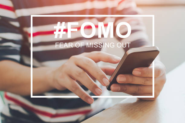 FOMO, fear of missing out concept. Close-up image of male hands using mobile smartphone FOMO, fear of missing out concept. Close-up image of male hands using mobile smartphone fomo stock pictures, royalty-free photos & images
