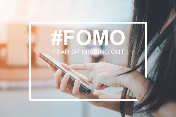 FOMO, fear of missing out concept. Close-up image of woman hand using mobile smartphone FOMO, fear of missing out concept. Close-up image of woman hand using mobile smartphone fomo stock pictures, royalty-free photos & images