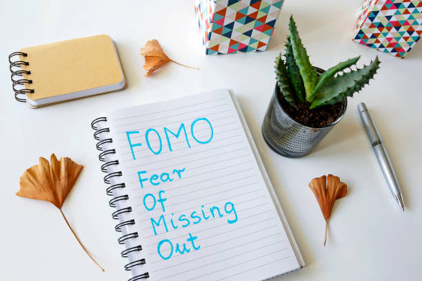 FOMO fear of missing out written in a notebook FOMO fear of missing out written in a notebook on white table fomo photos stock pictures, royalty-free photos & images