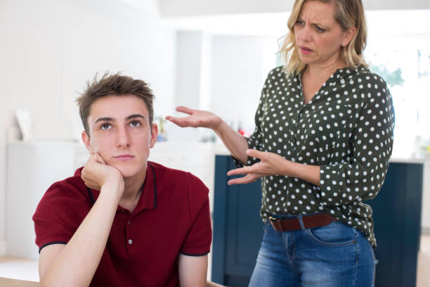 Fed Up Teenage Boy Being Nagged By Mother At Home Fed Up Teenage Boy Being Nagged By Mother At Home mother and teenage son stock pictures, royalty-free photos & images