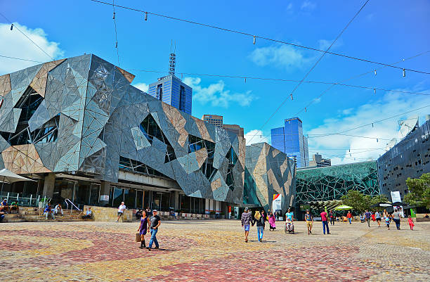 Federation Square in Melbourne city cetre Melbourne, Australia - January 18, 2015: People visit Federation Square in Melbourne city cetre on January 18, 2015. The square is a public space created in 2002 in the heart of Melbourne.  federation square stock pictures, royalty-free photos & images