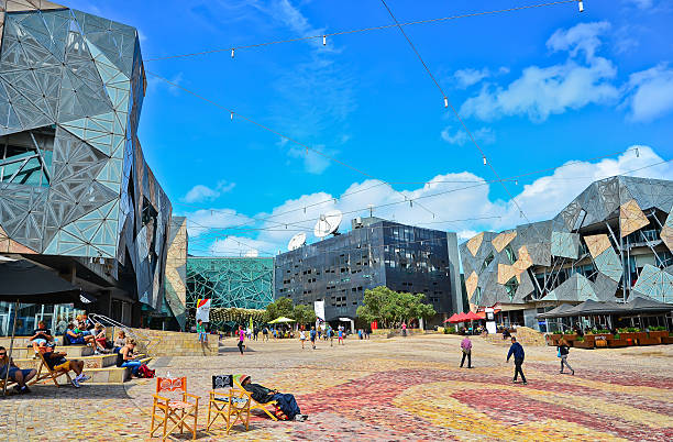 Federation Square in Melbourne city cetre Melbourne, Australia - January 18, 2015: People visit Federation Square in Melbourne city cetre on January 18, 2015. The square is a public space created in 2002 in the heart of Melbourne. federation square stock pictures, royalty-free photos & images