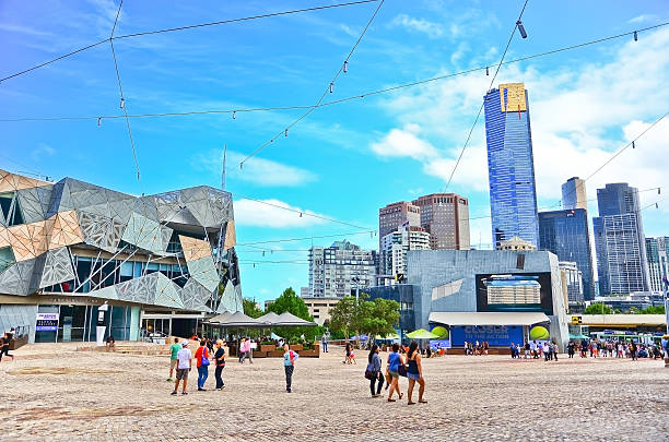 Federation Square in Melbourne city cetre Melbourne, Australia - January 18, 2015: People visit Federation Square in Melbourne city cetre on January 18, 2015. The square is a public space created in 2002 in the heart of Melbourne.  federation square stock pictures, royalty-free photos & images