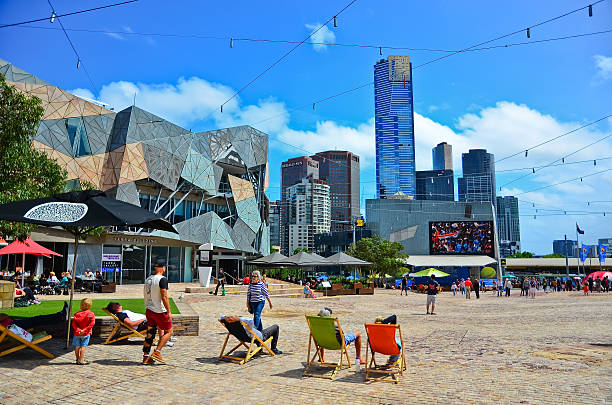 Federation Square in Melbourne Melbourne, Australia - January 18, 2015: People lying on the deckchair in a sunny day at the Federation Square in Melbourne city cetre on January 18, 2015.  federation square stock pictures, royalty-free photos & images