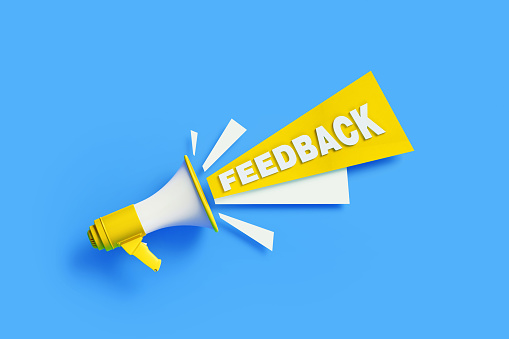 Feedback coming out from a yellow megaphone on blue background. Horizontal composition with copy space. Great use for survey and feedback concepts.