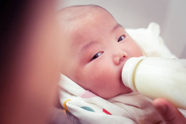кормление ребенка - baby formula стоковые фото и изображения