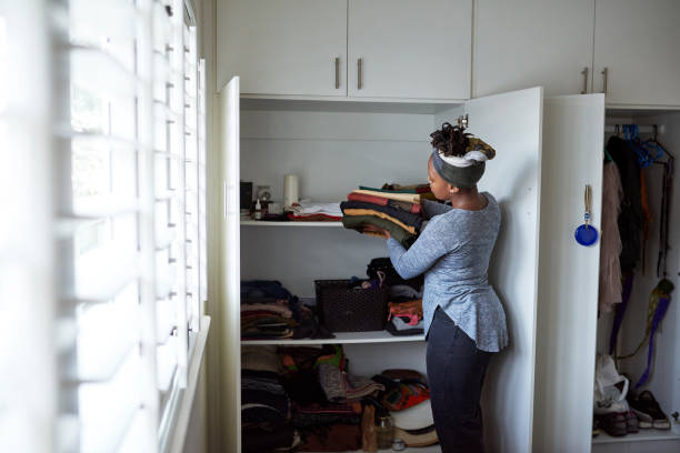 I feel better when everything is packed away Cropped shot of a young woman packing away clean laundry at home closet stock pictures, royalty-free photos & images