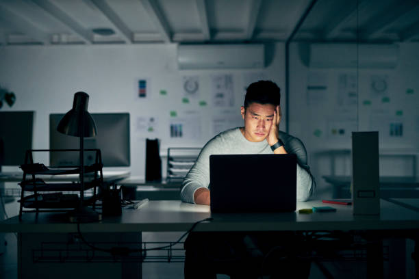 Feeling some serious FOMO right now Shot of a young businessman looking stressed during a late night in a modern office fomo photos stock pictures, royalty-free photos & images