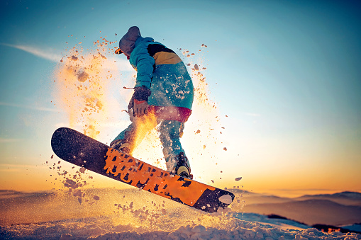 Snowboarder having fun at ski resort, skiing over the mountain