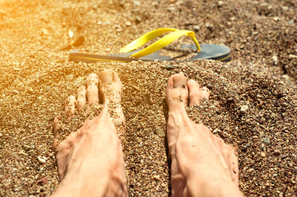 feet buried in the sand feet buried in the sand human feet buried in sand. summer beach stock pictures, royalty-free photos & images