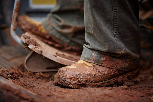 feet driving earth mover - muddy shoes stockfoto's en -beelden