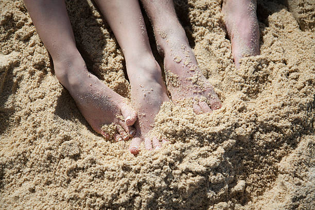 Feet in the sand A man and woman's feet in the sand human feet buried in sand. summer beach stock pictures, royalty-free photos & images