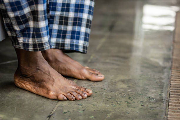 Feet of a nice African American man touching the floor Cold surface. Feet of a nice African American man touching the floor while sitting on the bed barefoot stock pictures, royalty-free photos & images