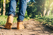 istock feet of an adult wearing boots to travel walking in a green forest. travel and hiking concept. 1299264393