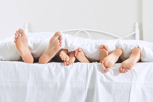 Feet of family in bed stock photo