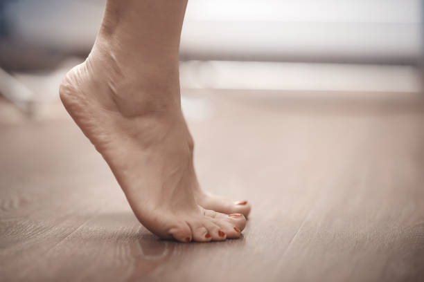 Feet of woman standing on tiptoe stock photo