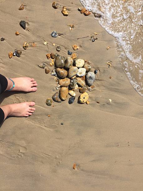 Feet on the beach with rocks stock photo