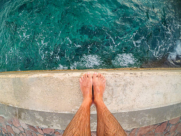 Feet pov on diving in to sea Feet pov on diving in to sea from port cliff jumping stock pictures, royalty-free photos & images