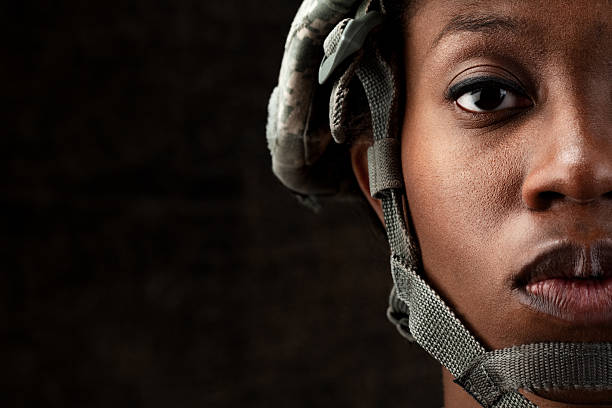 Female African American Soldier Series: Against Dark Brown Background Female African American soldier in army camouflage uniform and combat headgear. warrior person stock pictures, royalty-free photos & images