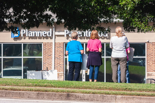 Female Anti-Abortion Protesters Stand Outside Georgia Planned Parenthood Clinic Lawrenceville, GA -  October 9, 2021:  Female anti-abortion protesters stand and stare at a Planned Parenthood clinic on October 9, 2021 in Lawrenceville, GA. abortion clinic stock pictures, royalty-free photos & images