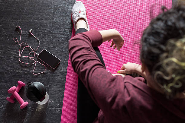 Female athlete resting on mat after achieved workout goals stock photo